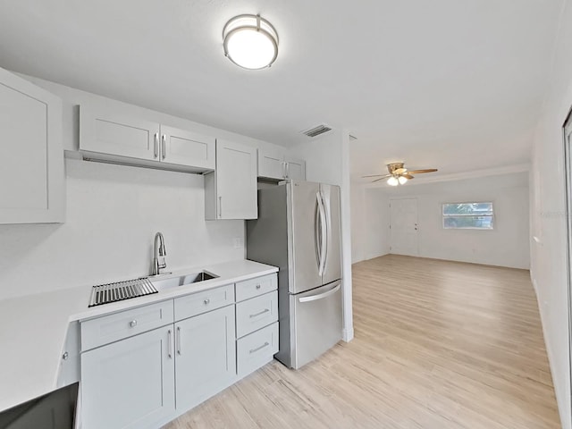 kitchen featuring ceiling fan, light wood-style flooring, visible vents, light countertops, and freestanding refrigerator