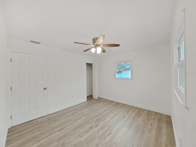 empty room with light wood-style floors, baseboards, and visible vents