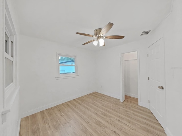 unfurnished bedroom with a closet, visible vents, light wood-style flooring, ceiling fan, and baseboards