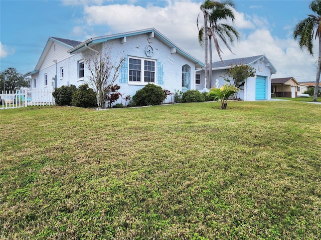 view of front of home featuring a garage, a front lawn, and fence