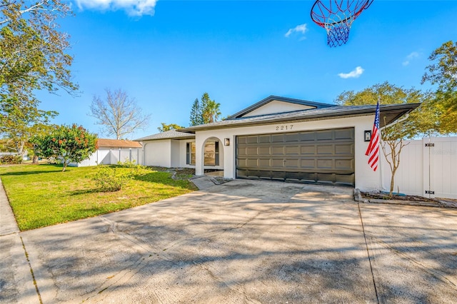 ranch-style home with a garage, concrete driveway, a front yard, and stucco siding