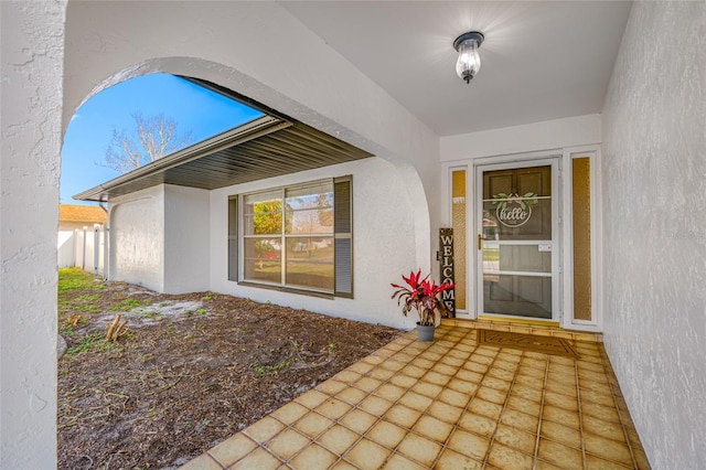 view of exterior entry with stucco siding