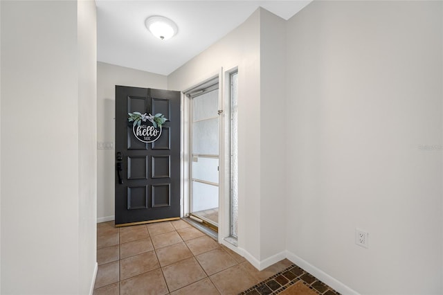 foyer featuring light tile patterned flooring and baseboards