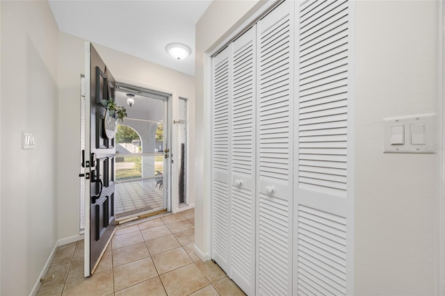 entrance foyer with light tile patterned flooring and baseboards