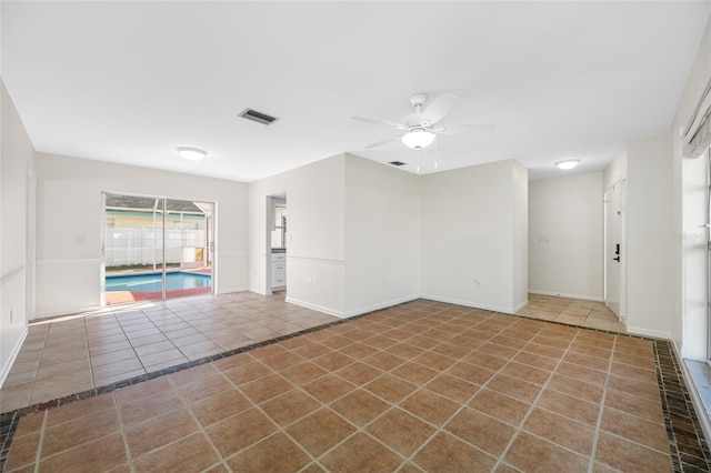 spare room featuring a ceiling fan, tile patterned flooring, visible vents, and baseboards