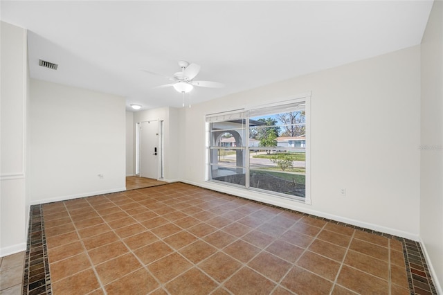 tiled empty room featuring visible vents, ceiling fan, and baseboards