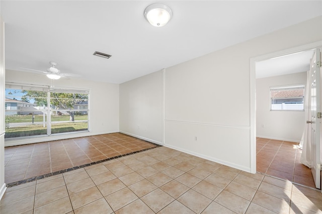 unfurnished room featuring baseboards, visible vents, a ceiling fan, and light tile patterned flooring