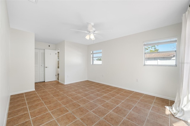 unfurnished room with a ceiling fan and baseboards