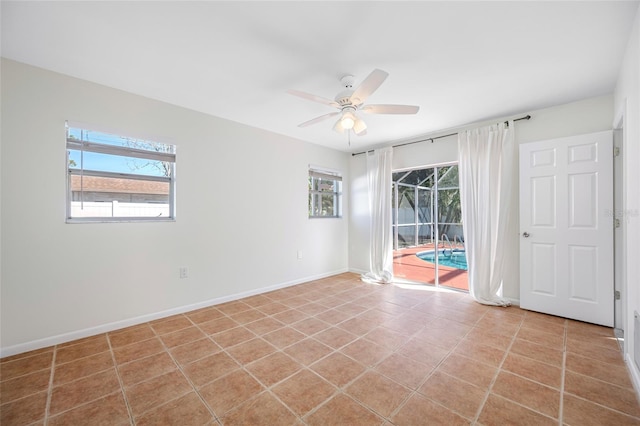 unfurnished room with a ceiling fan, a sunroom, baseboards, and light tile patterned floors