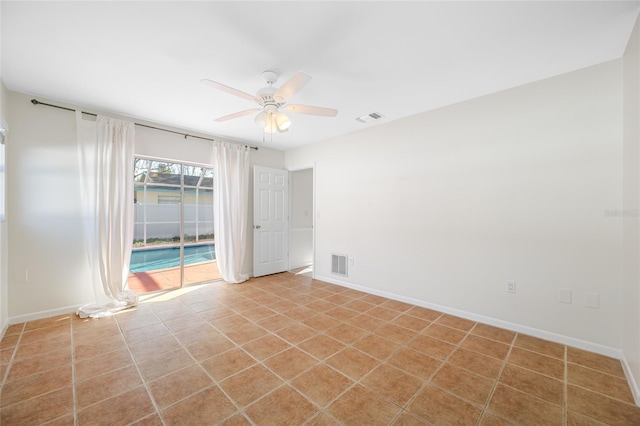 empty room with light tile patterned floors, ceiling fan, visible vents, and baseboards