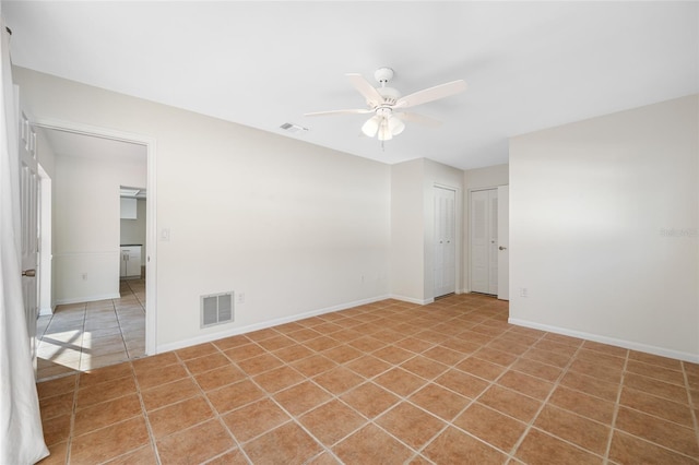 spare room featuring visible vents, ceiling fan, baseboards, and tile patterned floors