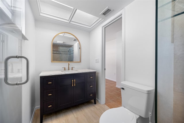 bathroom with toilet, vanity, visible vents, and baseboards