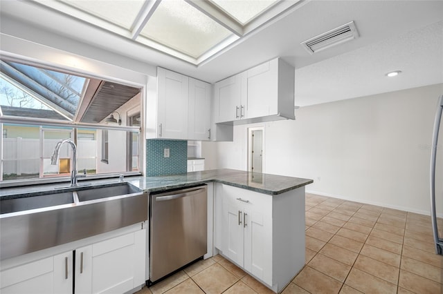 kitchen with light tile patterned flooring, a sink, visible vents, white cabinetry, and dishwasher