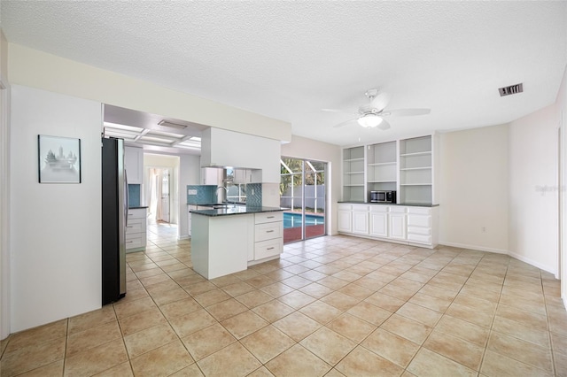 kitchen featuring dark countertops, visible vents, appliances with stainless steel finishes, a ceiling fan, and white cabinetry