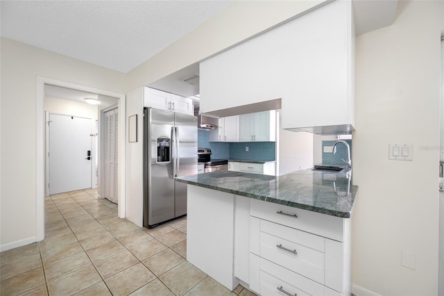 kitchen featuring a sink, white cabinetry, appliances with stainless steel finishes, backsplash, and dark stone counters