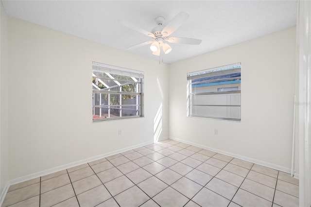 empty room with a ceiling fan and baseboards