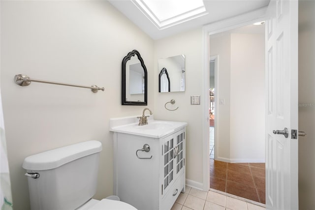 bathroom with toilet, tile patterned flooring, baseboards, and vanity