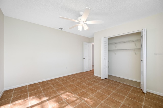 unfurnished bedroom featuring a textured ceiling, visible vents, baseboards, a ceiling fan, and a closet