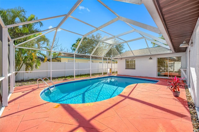 view of swimming pool with glass enclosure, a patio area, fence, and a fenced in pool