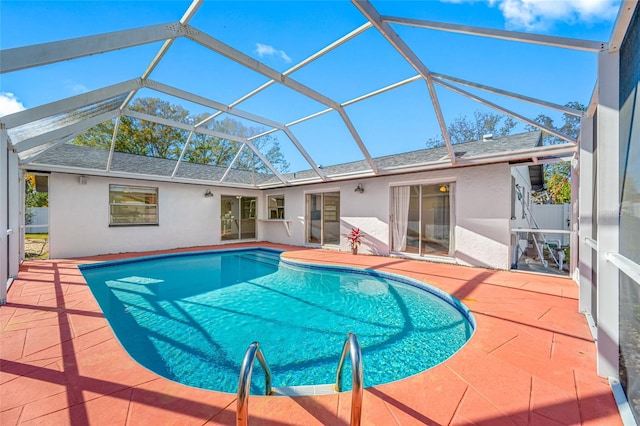 outdoor pool with a patio and glass enclosure