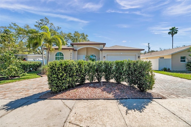 view of front of house with a garage, decorative driveway, and stucco siding