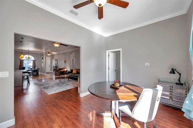 dining space with arched walkways, crown molding, wood-type flooring, visible vents, and baseboards