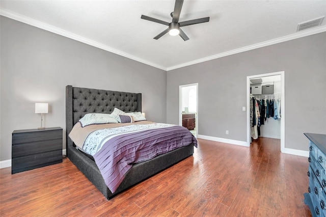 bedroom featuring baseboards, visible vents, wood finished floors, and ornamental molding