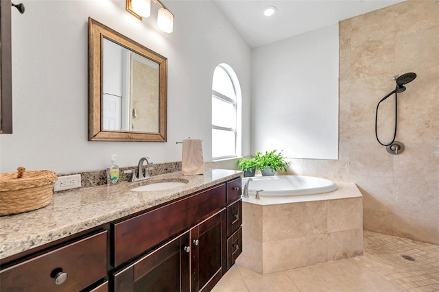 full bathroom featuring a garden tub, vanity, and tile patterned floors