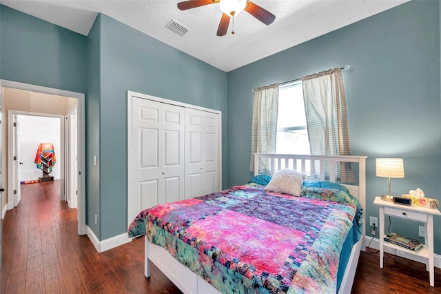 bedroom with baseboards, a closet, visible vents, and dark wood-style flooring