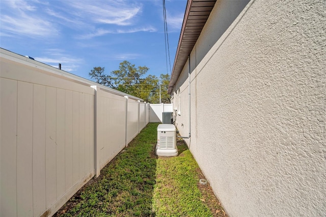 exterior space featuring a yard, cooling unit, and fence