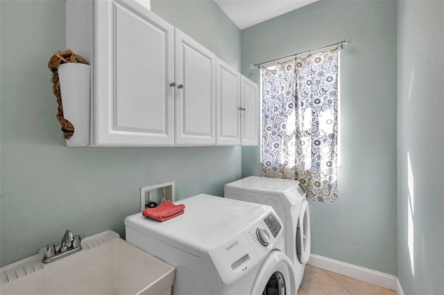 laundry room featuring cabinet space, light tile patterned floors, baseboards, washer and dryer, and a sink