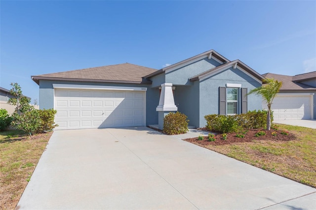 view of front facade featuring a garage, driveway, and stucco siding