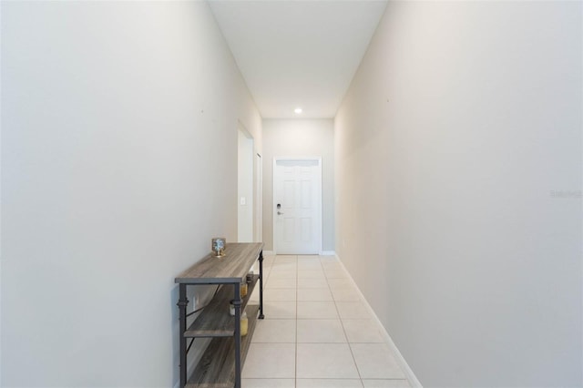 hall with light tile patterned flooring and baseboards