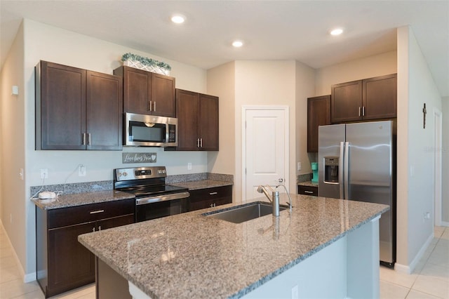 kitchen featuring dark brown cabinetry, light stone countertops, stainless steel appliances, a sink, and recessed lighting