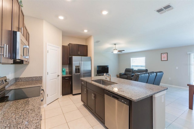 kitchen with a center island with sink, stainless steel appliances, visible vents, open floor plan, and a sink