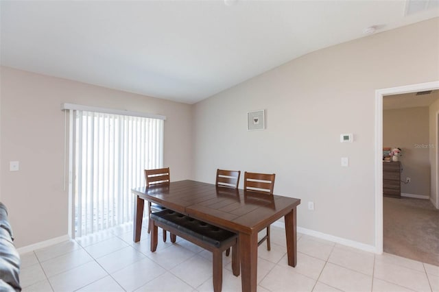 dining room with visible vents, baseboards, vaulted ceiling, and light tile patterned flooring