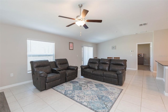 living area featuring visible vents, baseboards, lofted ceiling, ceiling fan, and light tile patterned flooring