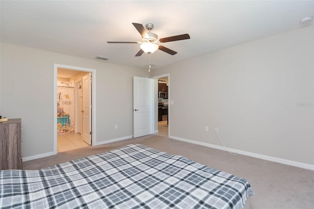 unfurnished bedroom with baseboards, visible vents, light colored carpet, ensuite bath, and ceiling fan