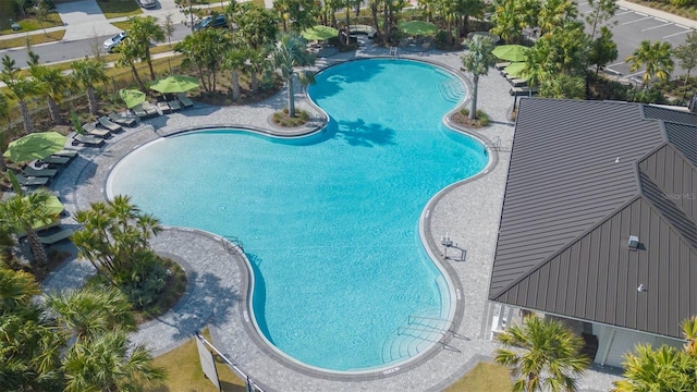 community pool with a patio and fence