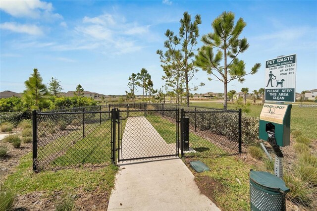 view of gate with a yard and fence