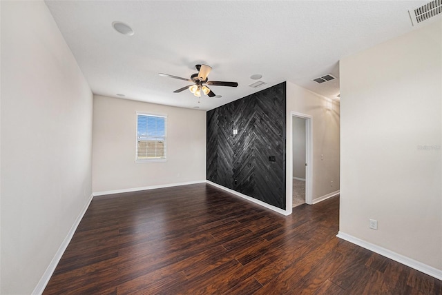 empty room featuring visible vents, baseboards, and wood finished floors