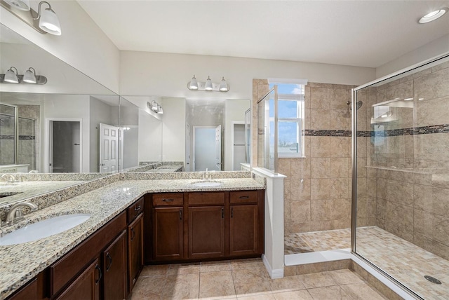 full bathroom with a stall shower, tile patterned floors, a sink, and double vanity