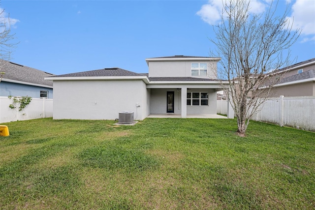 rear view of house with a fenced backyard, a patio, a lawn, and stucco siding