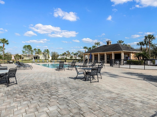 community pool with fence and a patio