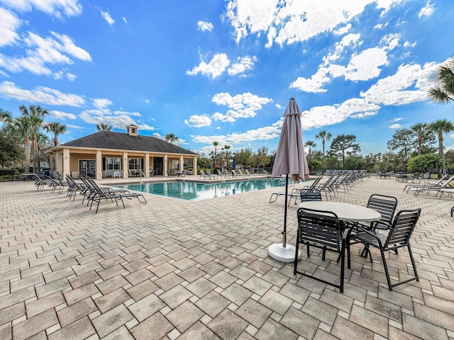 pool with a patio area and fence