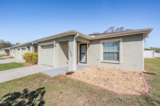 ranch-style home with a garage, concrete driveway, and stucco siding