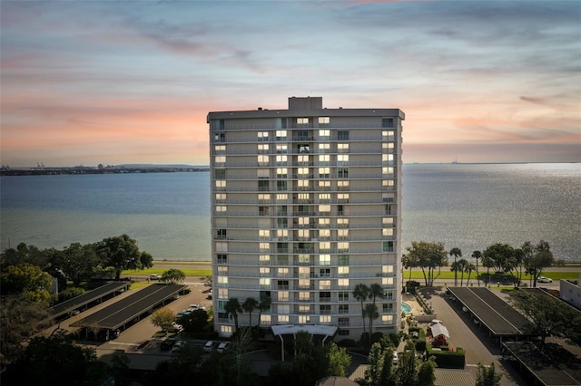 property at dusk featuring a water view