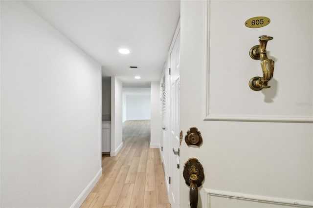hallway featuring visible vents, recessed lighting, light wood-style floors, and baseboards