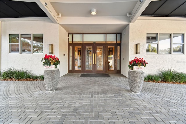 property entrance with stucco siding and french doors