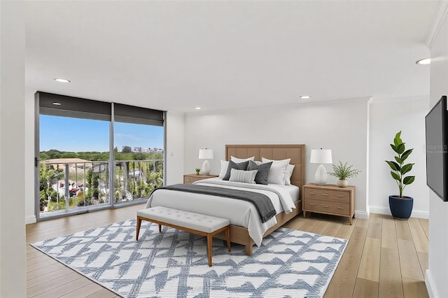 bedroom featuring recessed lighting, floor to ceiling windows, baseboards, and light wood-style floors